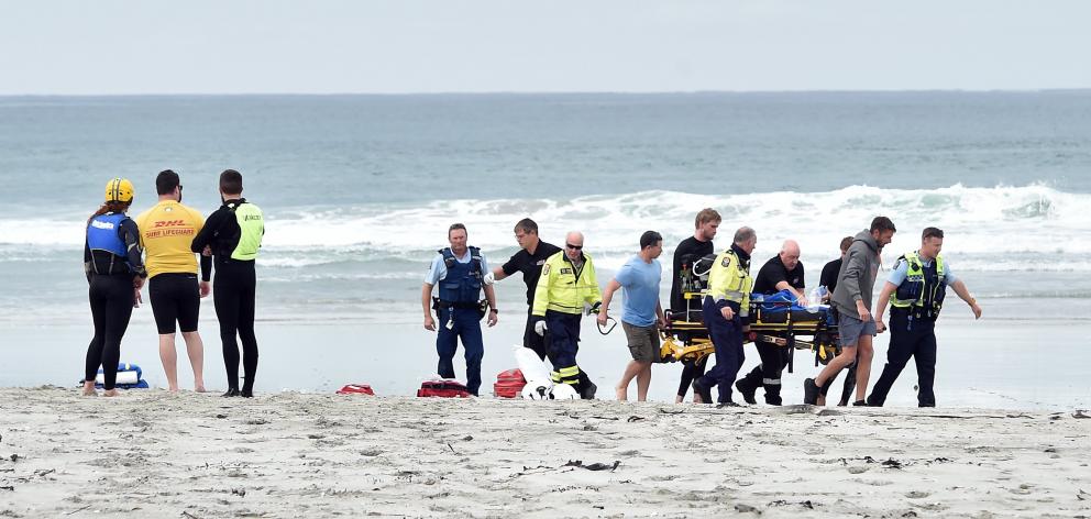 Emergency services carry a patient following a boat capsize in Taieri Mouth on Saturday. One...