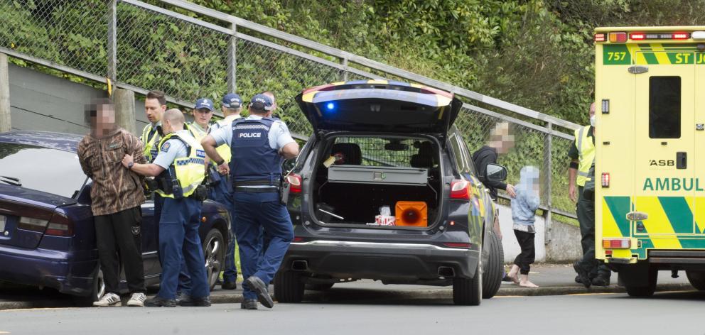 Police restrain a man at the scene of a single-vehicle crash in George St, Dunedin, yesterday,...