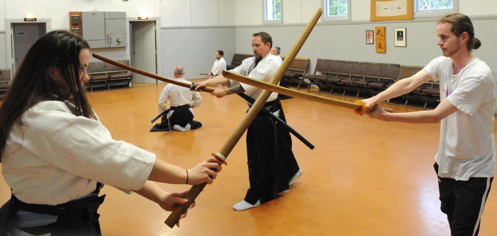 Brenda Hattingh performs a mock duel with Wyatt Ryder as Cameron Lindsay teaches from behind.