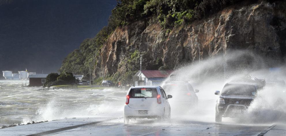 Cars crossing the Portobello Rd causeway, in Dunedin, battle waves blown up by gale-force winds...