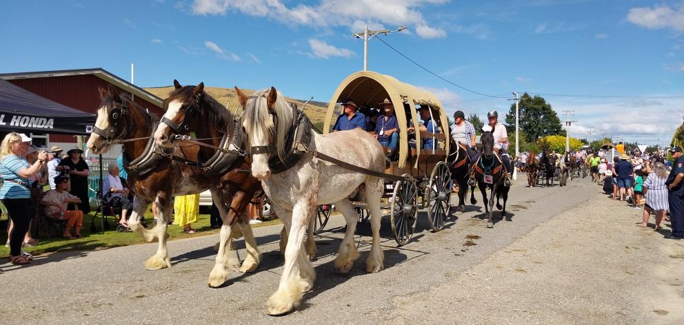 Heavy wagon trail members make their way down the crowd-lined main street of Waikaia during the...