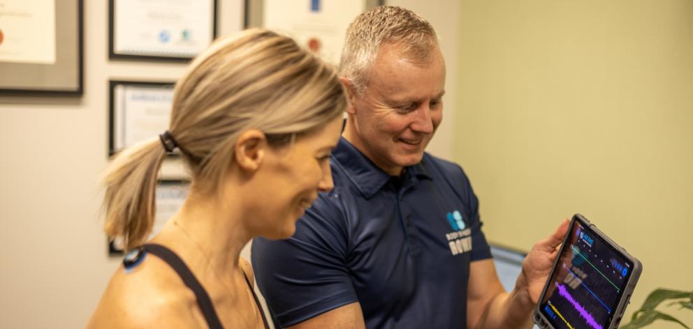 Rowan Ellis using the MR EMG biofeedback technology to assess his clients Trapezius muscles.