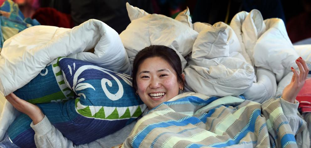 Bedding bank volunteer Wingkei Chen cozied up in the many blankets up for grabs at the Winter...