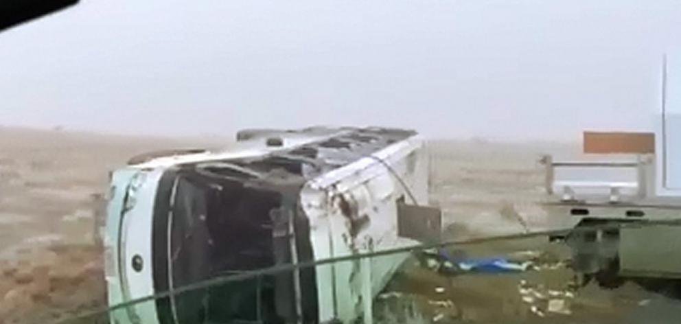 A badly damaged bus lies on its side after crashing off State Highway 8 near Lake Pukaki...