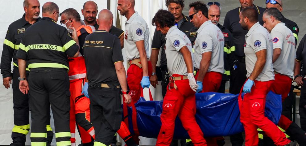 Rescue personnel transport a body recovered from the sunken luxury yacht. Photo: Reuters 