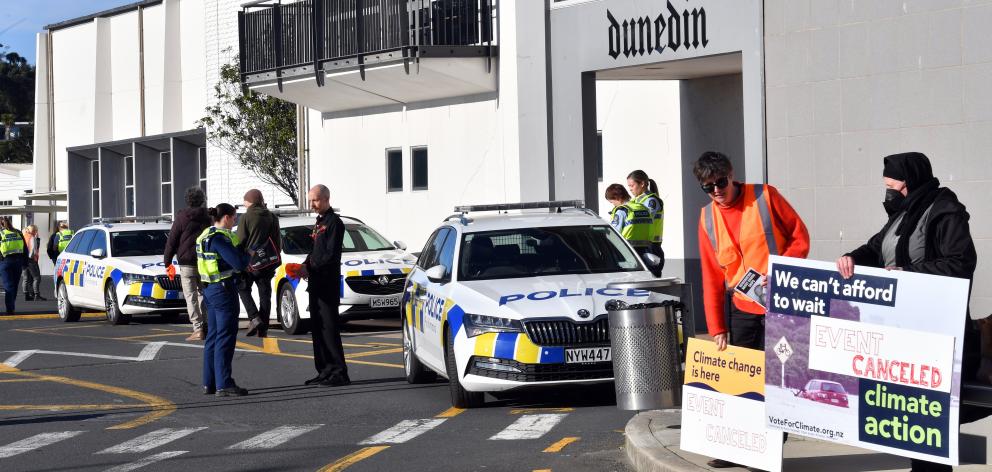 Police talk to climate protesters outside the Edgar Centre after a few of their number disrupted...