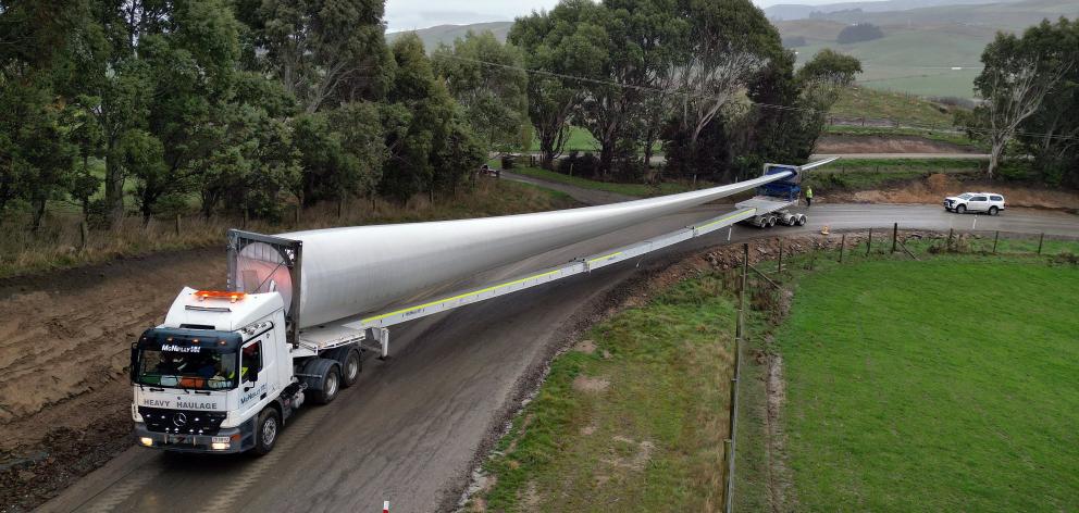 A specially rigged truck and trailer transports the first, 67m turbine blade, up Hillary road to...