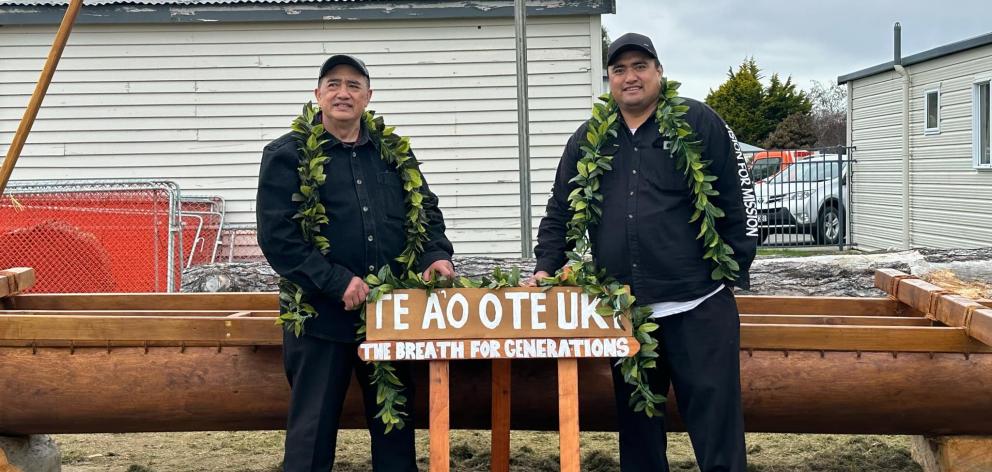 Master carver Taua Papatua (left) and his son Samuel Papatua showing proudly the vaka they carved...