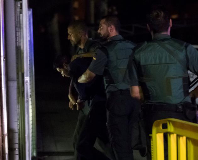 Spanish Civil Guards escort one of four men accused of the van attack. Photo: Reuters 