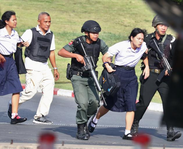 Thai security forces evacuate students stranded inside the Terminal 21 shopping mall following a...