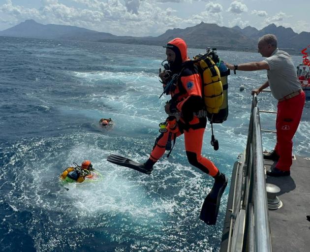 Divers operate in the sea to search for the missing after a luxury yacht sank off Sicily, Italy....