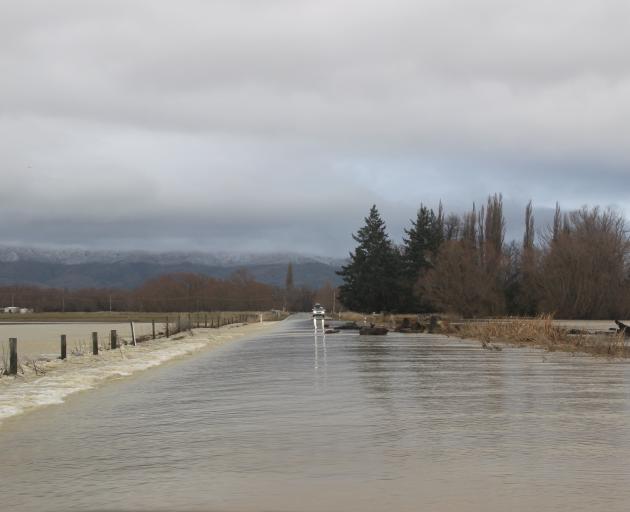 Water gushes onto the road between Omakau and Ophir on Saturday. Photo: Jono Edwards 