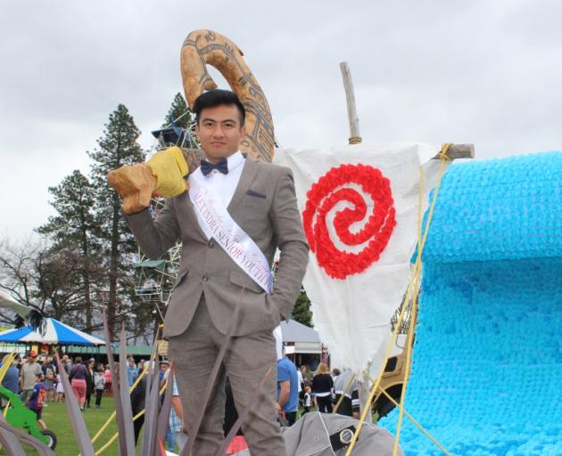 Blossom Festival prince Jeff Afan holds a Maui fish hook on a Moana-themed float. PHOTO: JONO...