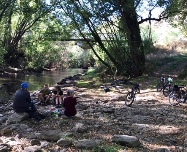 Jones family members rest alongside the Teviot River while cycling part of the CLutha Gold Cycle...