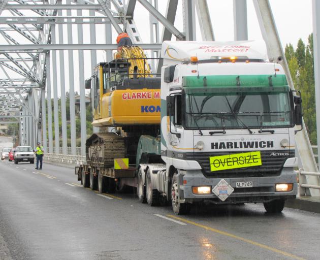 A man works to free the arm of an excavator that became stuck under the Alexandra bridge. PHOTO:...