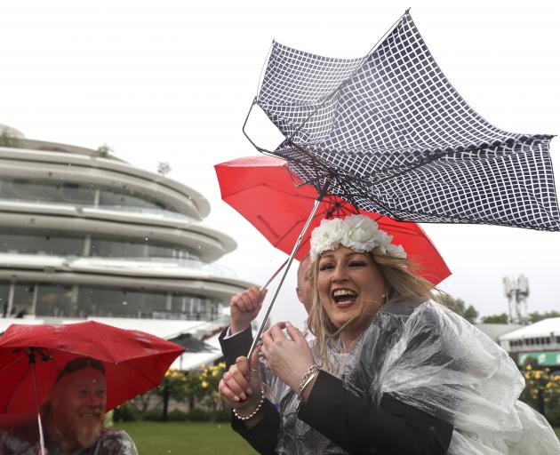 Punters brave the stormy conditions at Flemington as the weather closed in. Photo: Getty Images