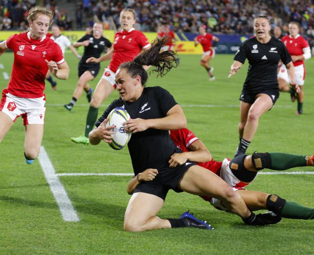 Portia Woodman of the Black Ferns is tackled during tonight's quarter-final match against Wales...