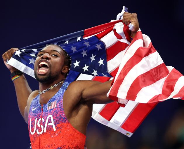 Noah Lyles, of the United States, celebrates winning gold in the men’s 100m final at Stade de...