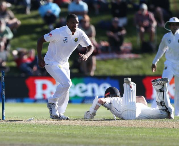 Kane Williamson slides over the crease to avoid a runout by Vernon Philander on day two at University Oval. Photo: Getty Images 