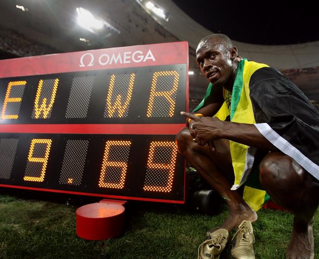 Usain Bolt poses by the clock displaying his winning time after the men’s 100m Olympic final in...