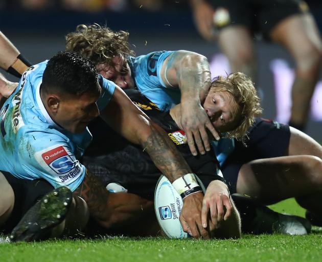 Damian McKenzie of the Chiefs scores despite desperate defence from the Waratahs in Hamilton....