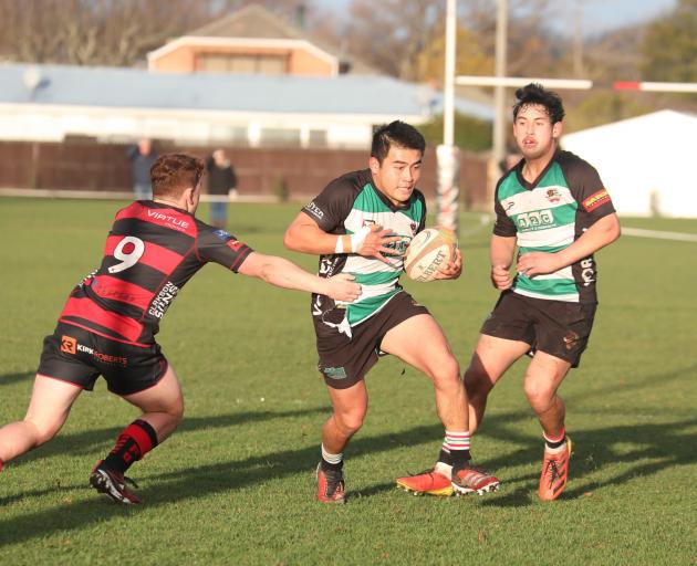 Marist Albion first-five eighth Shun Miyake tries to evade a tackle during his side’s 70-12 win...