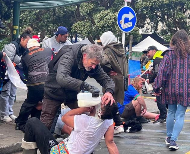 Protesters pouring milk in their eyes after pepper spray. Photo: RNZ/Charlotte Cook