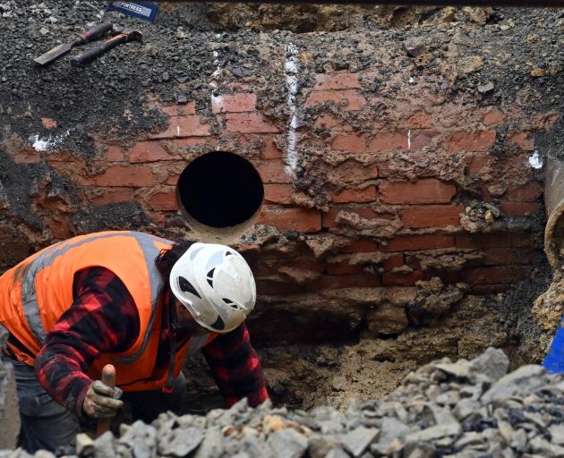 Downer excavator operator Hamish Lourie works on the excavation of the 1887 brick barrel main in...