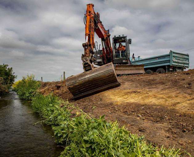 Fulton Hogan provided resources and machinery to help Leeston Consolidated School pupils restore a local stream, including reshaping the steep banks. Photo: Supplied