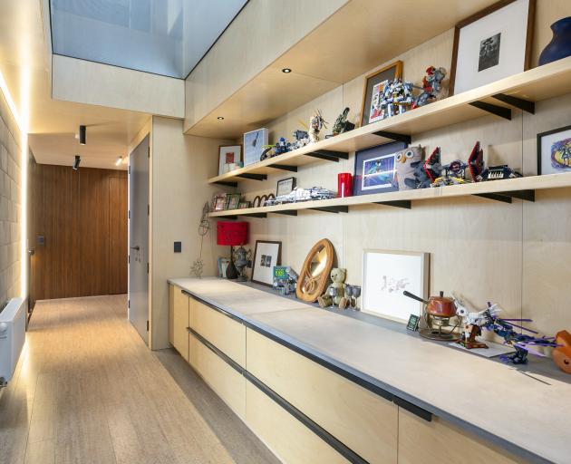 Storage and display space are built into the hall near the children’s bedrooms. The semi-opaque...