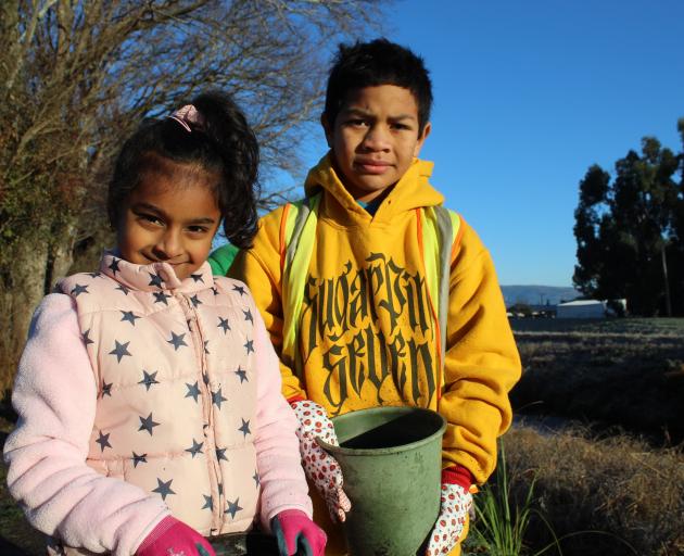 Amana Christian School pupils Brielle Mani (5, left) and Christiaan Faosiliva (7) get ready to...