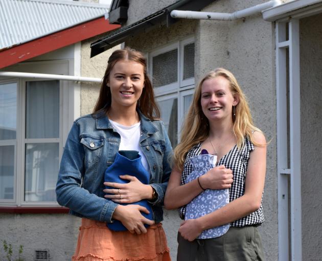 University of Otago students Olivia Hammond (left) and Karina Robins hug their hot-water bottles...