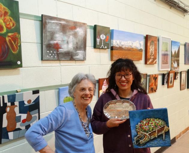 Wakari Art Group member Song Hue (right) accepts the ‘‘people’s choice’’ award from long-standing...