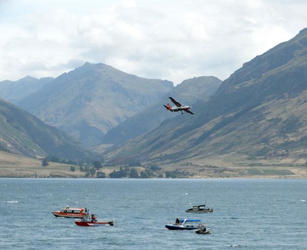 Planes, boats and jet skis search for the missing skydiver in Lake Wakatipu yesterday. Photo:...