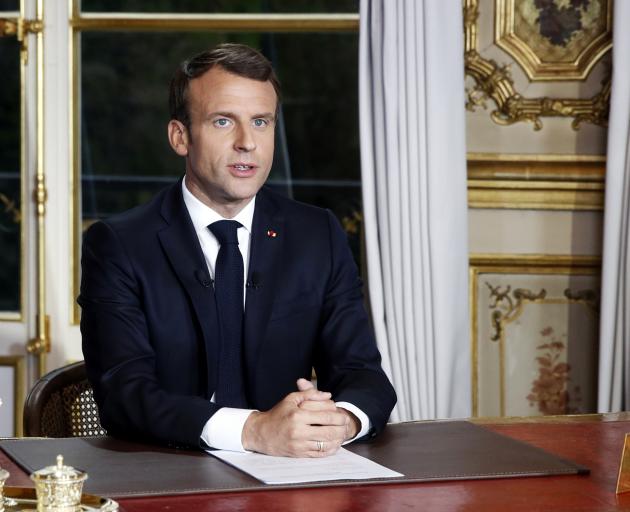 French President Emmanuel Macron addresses the French nation following a massive fire at Notre...