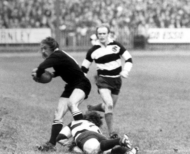 New Zealand's Bob Burgess (left) looks to pass the ball as he is tackled in a match against the...