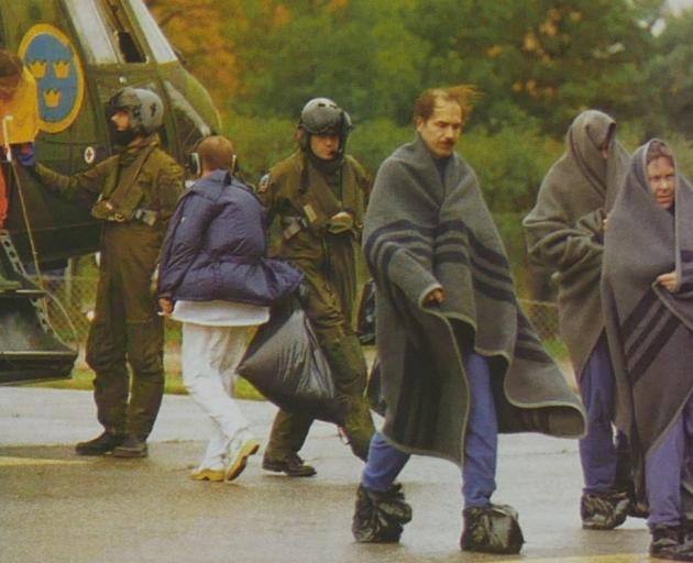 Survivors of the disaster disembark from a Swedish military helicopter. 