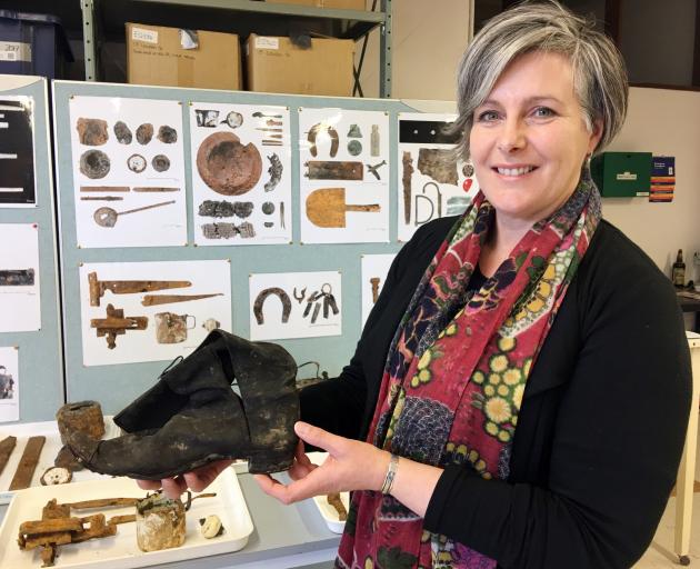 University researcher Dr Karen Greig holds a boot uncovered during a University of Otago...