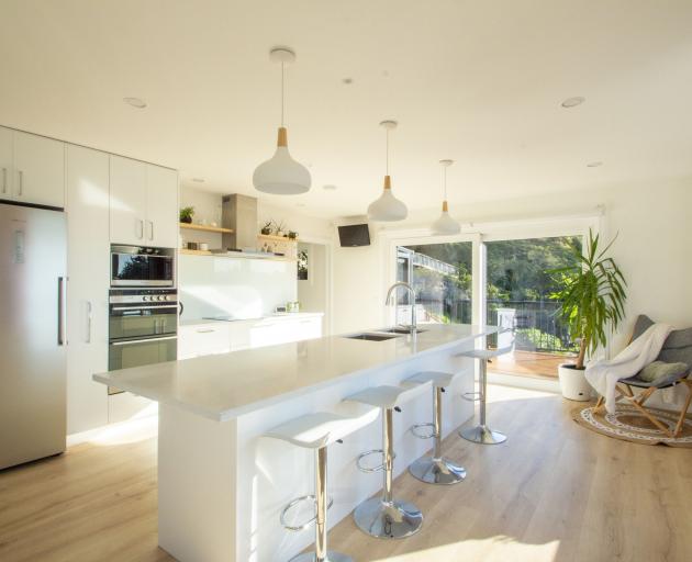 The breakfast bar in the kitchen gets a lot of use. A butler’s pantry is located behind; sliding...