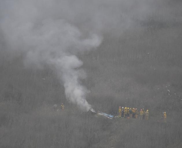 LA county firefighters work at the scene of a helicopter crash that reportedly killed Kobe Bryant...