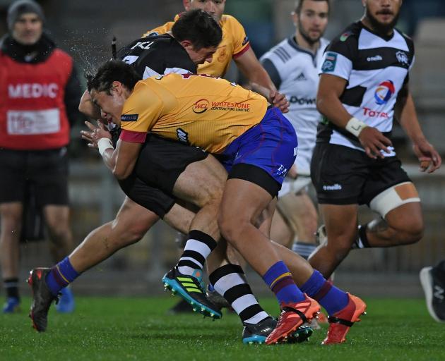 Hawke’s Bay flanker Will Tremain is tackled hard by North Otago fullback Mataroa Maui during the...