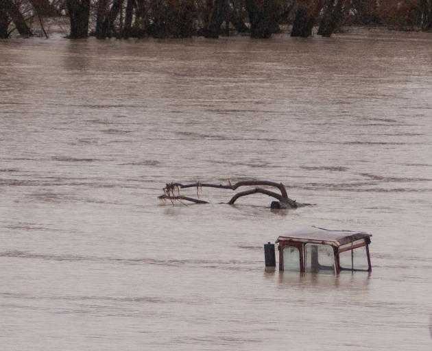 The tractor submerged under floodwaters in Omakau on Tuesday was revealed yesterday (below)....