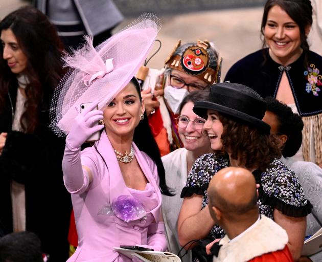 Singer Katy Perry takes selfies with guests during the coronation of King Charles III and Queen...