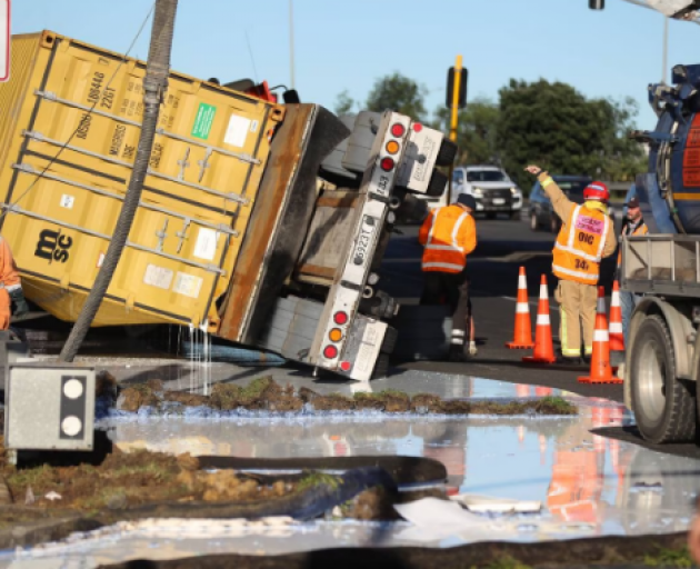 A container truck has rolled, spilling tonnes of carpet glue across State Highway 20 in Auckland....