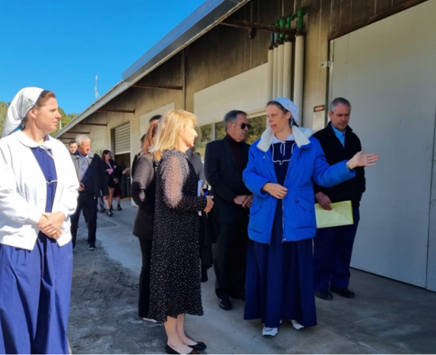 Purity Valor shows Chief Employment Court Judge Christina Inglis around Gloriavale on 24 February...