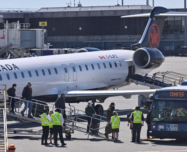 Passengers from Yellowknife disembark after being evacuated from wildfires threatening their city...