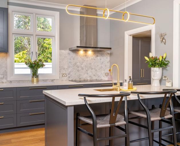 Light-coloured bench tops, brass finishes and timber-look flooring create a calm ambience in this...