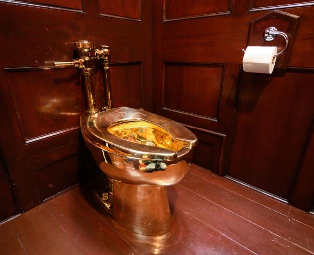 America, a fully-working solid gold toilet, created by artist Maurizio Cattelan, is seen at...