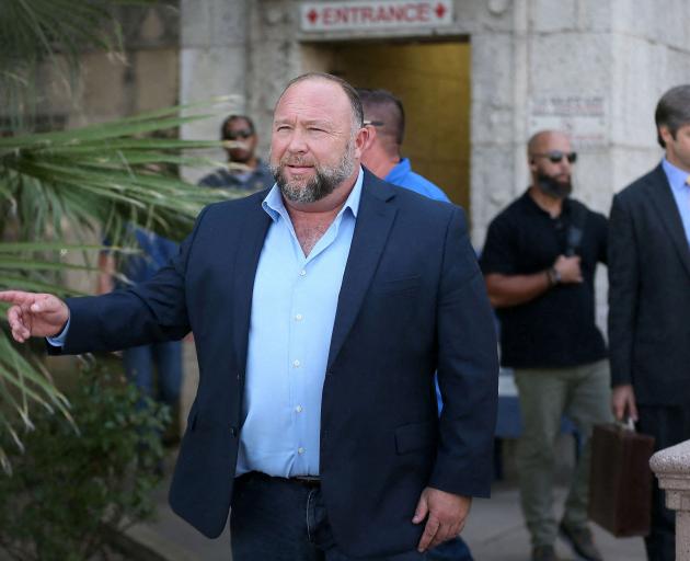 Internet influencer Alex Jones steps outside the Travis County Courthouse to do interviews with...