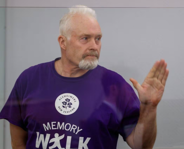 Barry Young waving to supporters as he enters the dock. Photo: NZ Herald